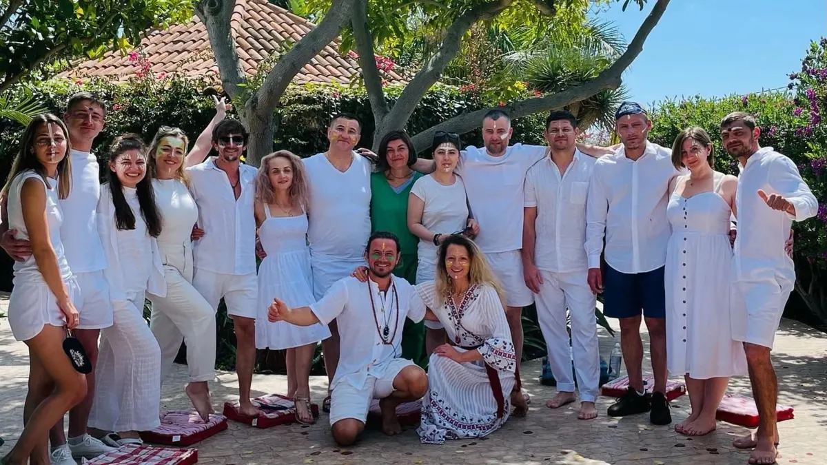 Grupul îmbrăcat în alb, cu fețele pictate, în grădină