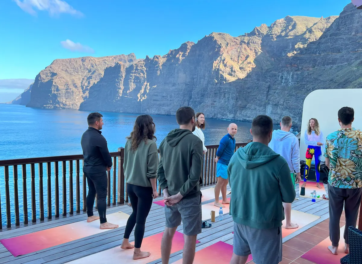 Participanți la retreat pe o terasă deasupra oceanului, în Tenerife